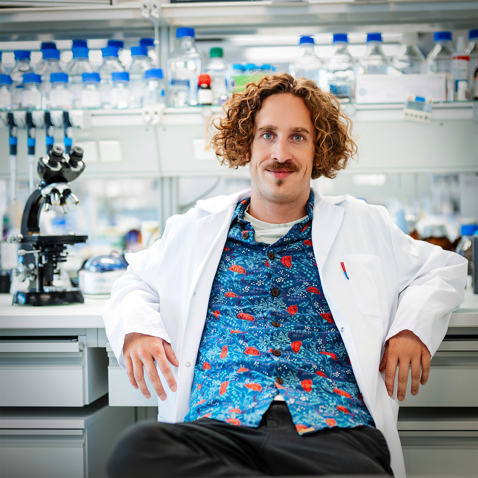 Philipp Dexheimer ina lab coat in front of a chemistry lab